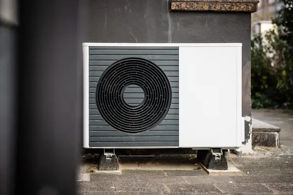Eine Wärmepumpe steht vor einer Hauswand