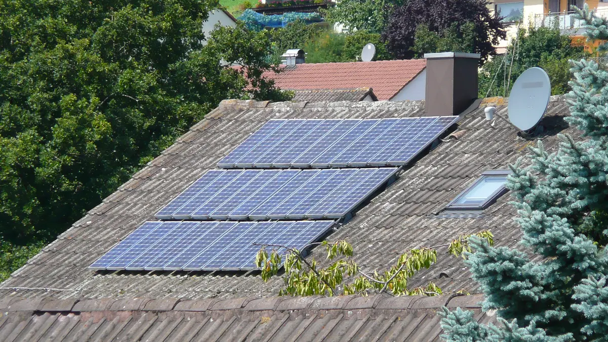 Eine alte Solaranlage auf einem Hausdach.