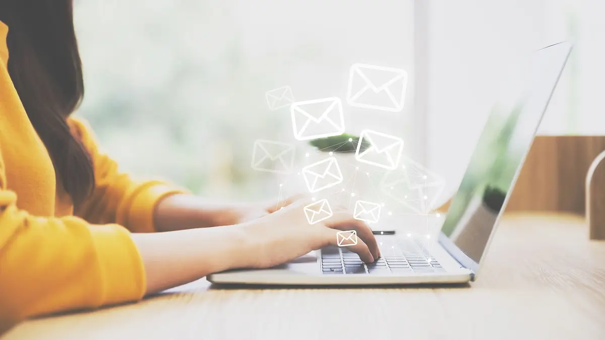 Frau an Laptop, die Mails schreibt.