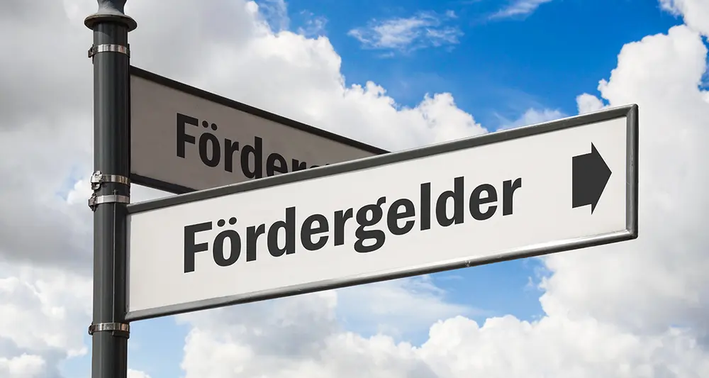 Straßenschild mit Pfeil Richtung "Fördergelder"