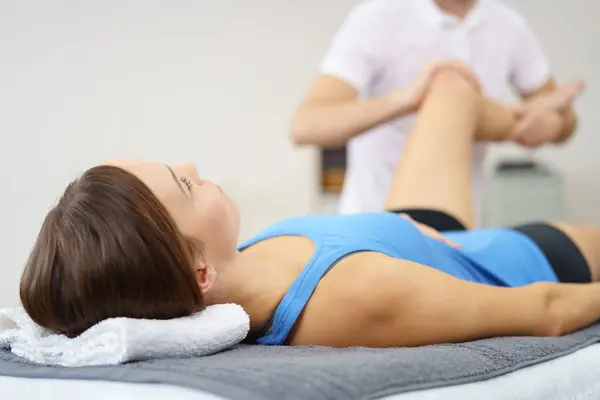 Eine Frau liegt auf einer Liege bei der Physiotherapie