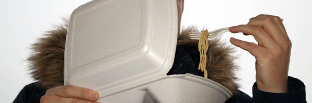 Mann ist Nudeln aus Plastikschale