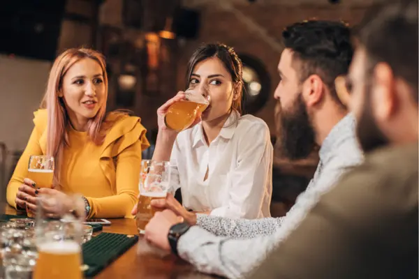Vier Leute trinken ein Bier in einer Bar. 