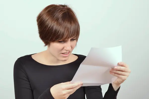 Frau blickt entsetzt auf Brief
