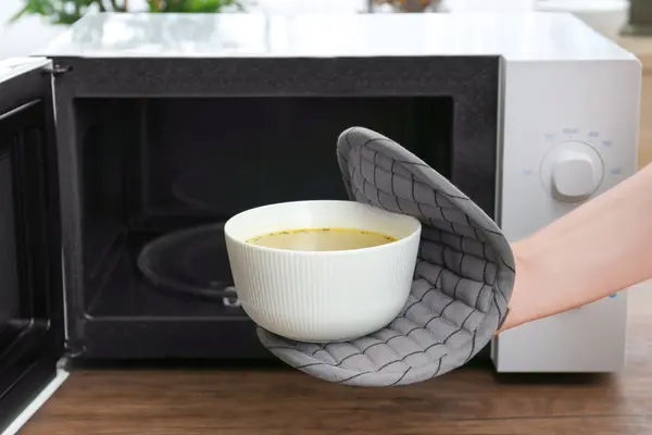 Mikrowellengerät davor eine Schüssel mit Suppe