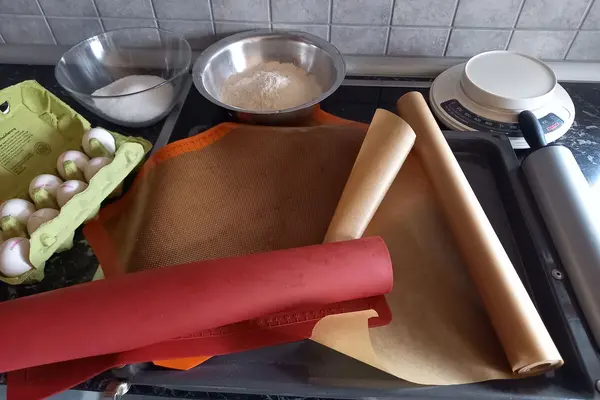 Auf einem Backblech liegen Backpapier und zwei Backmatten.
