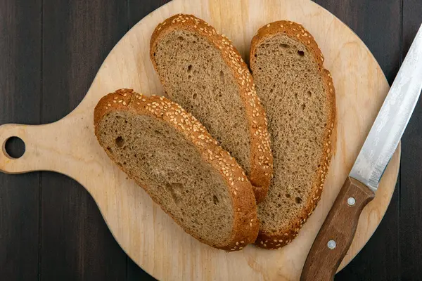 Brotscheiben und ein Messer auf einem Schneidebrett