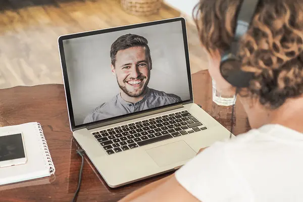 Frau nimmt per Laptop an einem Coaching teil