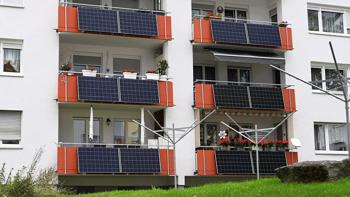 Hausfront mit mehreren Balkonen mit Steckersolarmodulen