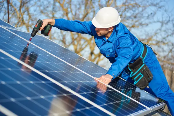 Ein Handwerker installiert eine Photovoltaik-Anlage.