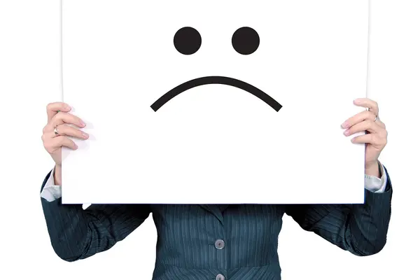 Frau hält großes Plakat mit einem Ärger-Emoticon vor ihr Gesicht