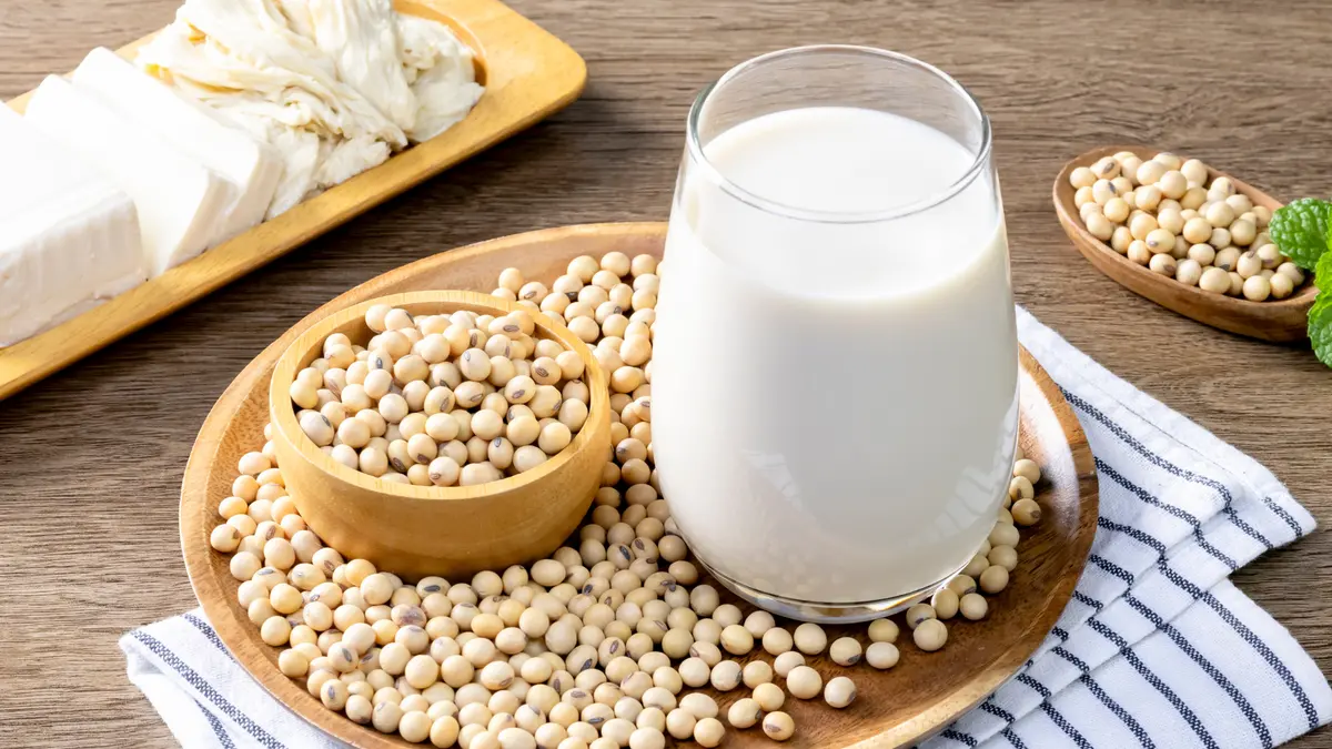 Sojabohnen und Soja-Milch auf einem Tablett auf einem Tisch