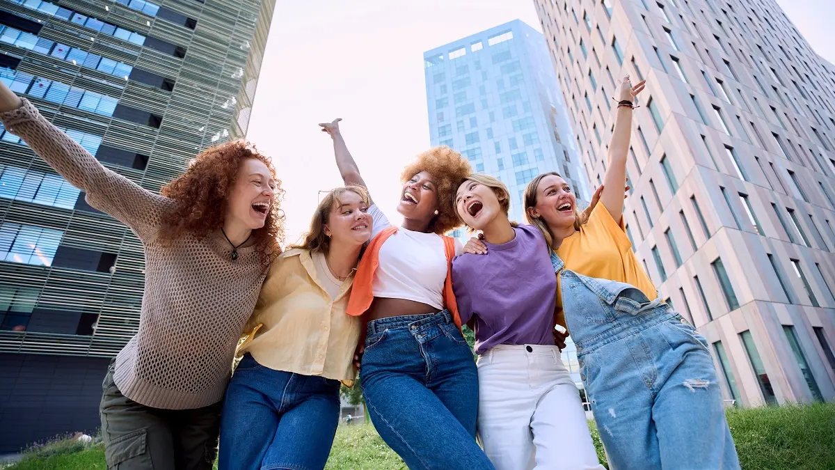 Fünf junge Frauen Arm in Arm.