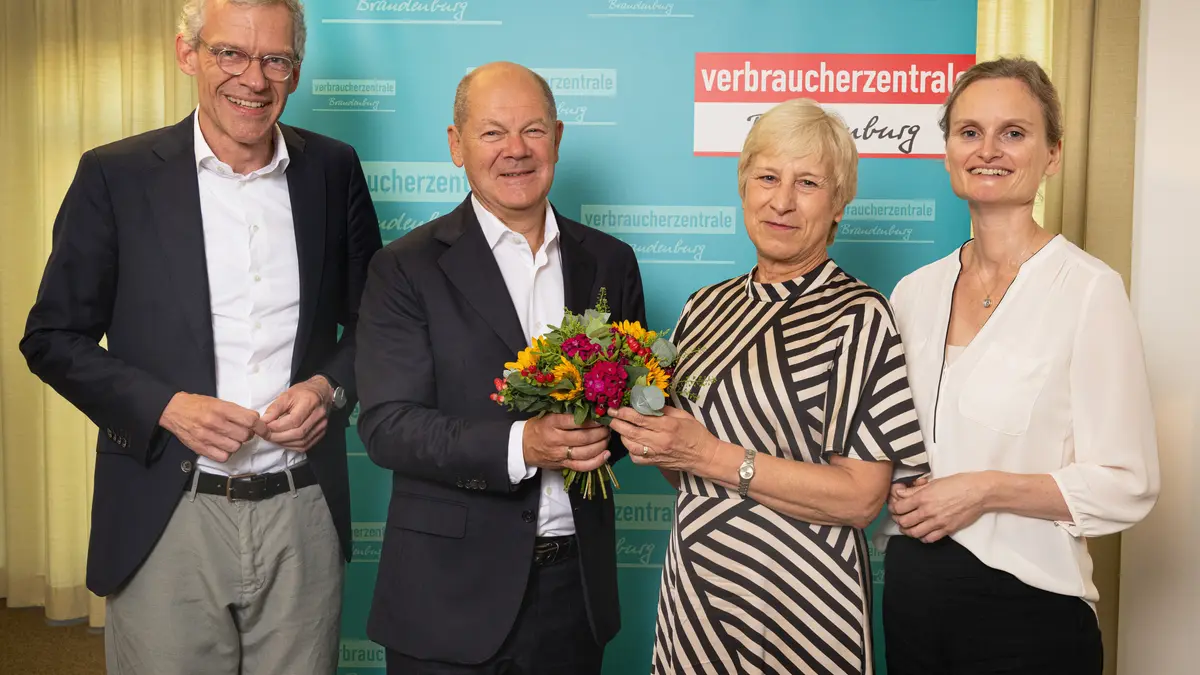 Olaf Scholz überreicht zu ihrer Verabschiedung Blumen an die langjährige Beratungsstellen-leiterin Sylvia Schönke in der Potsdamer Verbraucherzentrale, mit VZB-Geschäftsführer Christian A. Rumpke (l.) und Juristin Stefanie Kahnert (r.)
