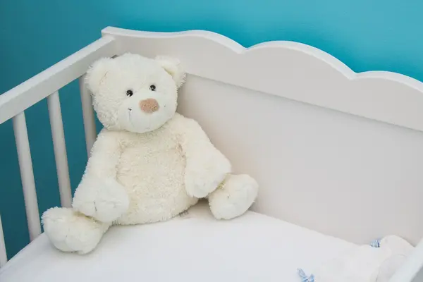 Babybett mit einem Teddybären