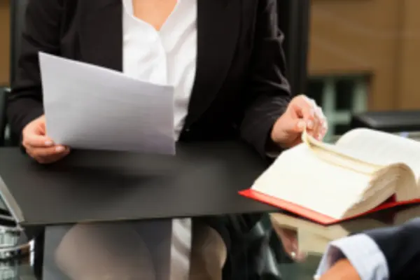 Frau schaut auf einen Brief und ein Gesetzbuch