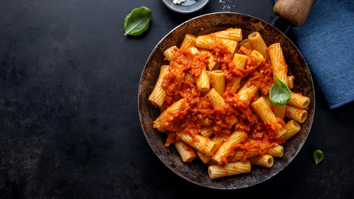 Nudeln in Tomatensauce auf einem dunklen Teller