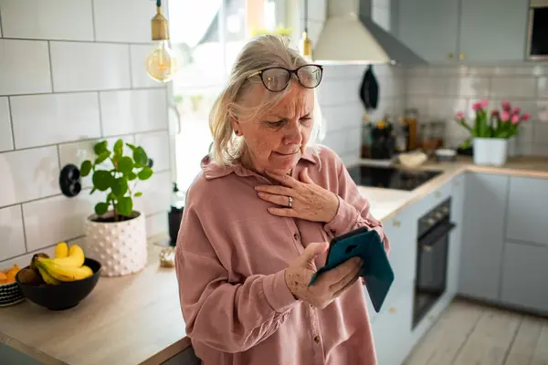 Frau schaut besorgt auf ihr Smartphone