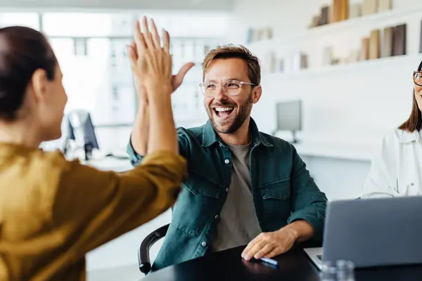 Ein Team gratuliert sich zum Erfolg im Büro.