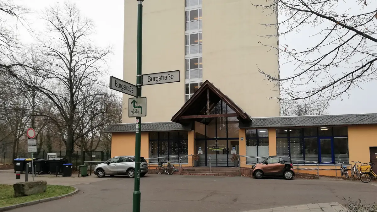 Auf dem Foto ist der Haupteingang der Josephinen-Wohnanlage abgebildet. Davor ist das Straßenschild mit der Aufschrift Burgstraße zu sehen.
