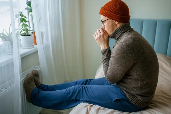 Mann versucht Heizkosten zu sparen und zieht sich in der Wohnung warm an