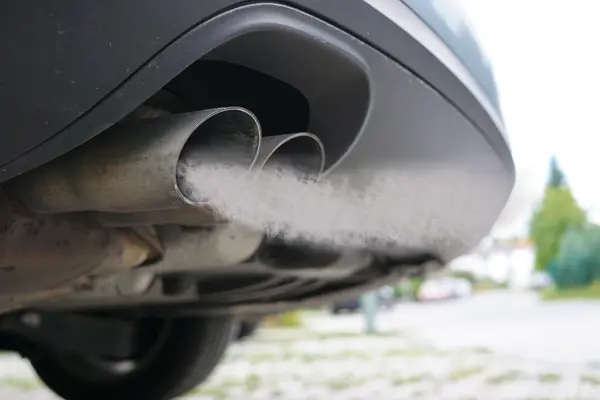 Abgase strömen aus einem Autoauspuff.