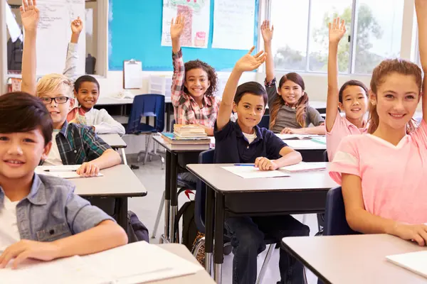 Kinder im Klassenzimmer melden sich eifrig