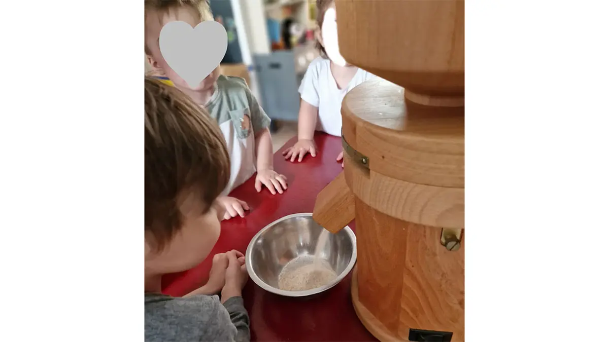 Kinder sehen beim Mahle der Getreidemühle zu