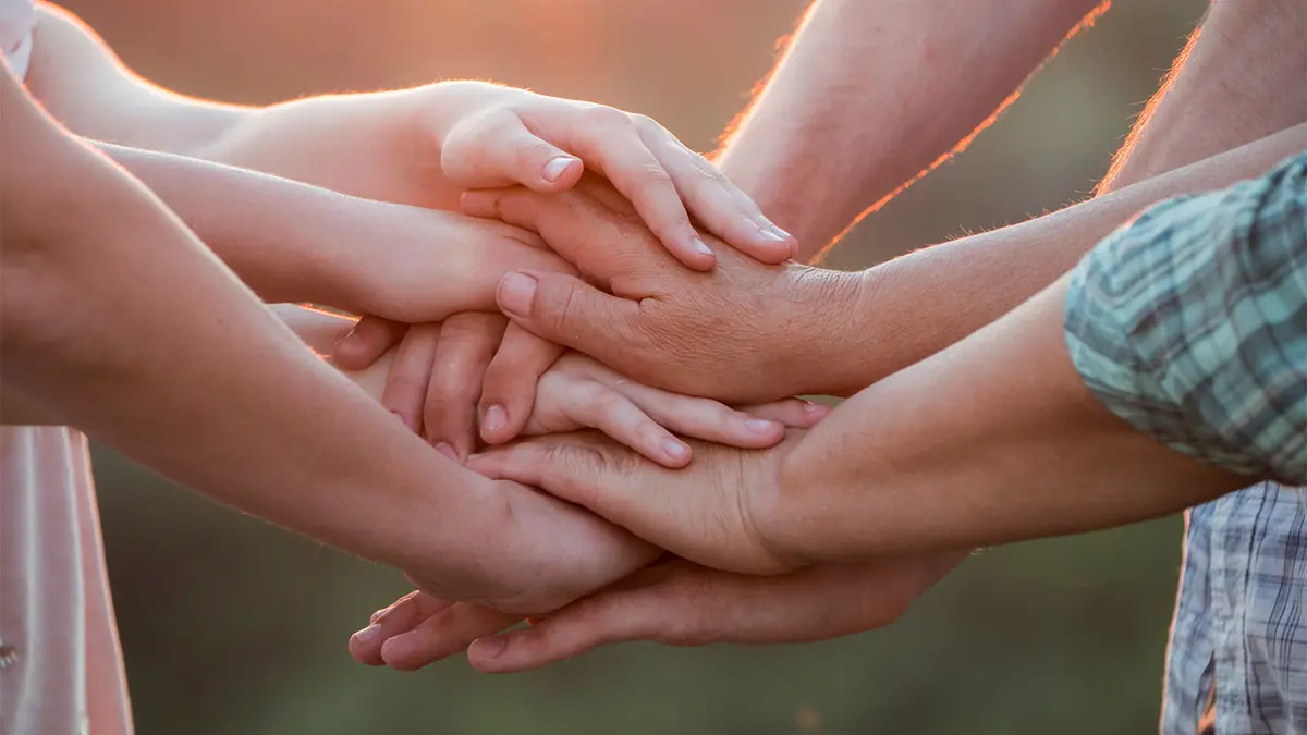 Mehrere Menschen haben ihre Hände übereinandergelegt