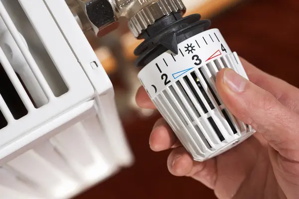 Verbraucher dreht seine Heizung am Thermostat auf Stufe 3