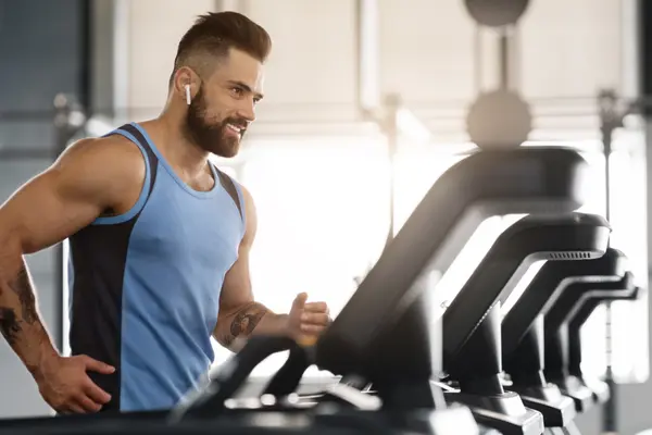 Ein Mann trainiert im Fitnessstudio auf einem Laufband