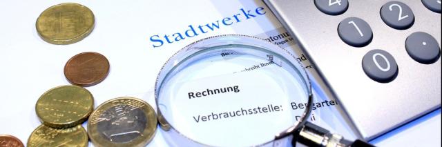 Rechnung mit Taschenrechner, Geld und Lupe