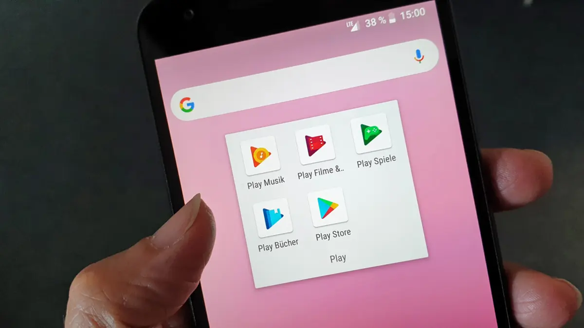Hand hält Smartphone mit App-Icons von Google Play