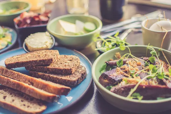 Mehrere Teller mit Brot und anderen Ballaststoff-reichen Lebensmitteln