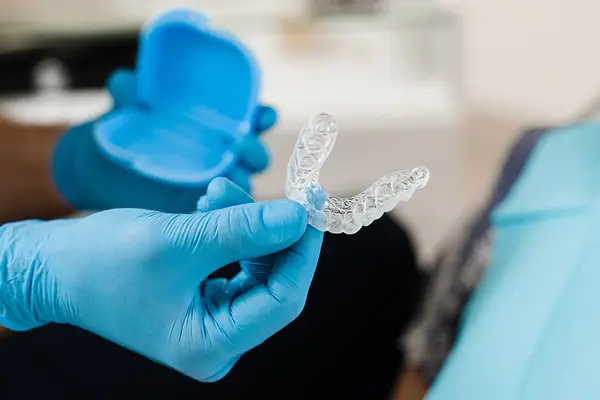 Kieferorthopäde zeigt eine durchsichtige Zahnschiene