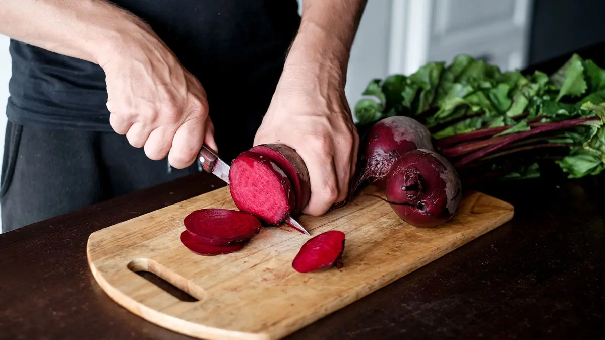 Frau schneidet rote Beete