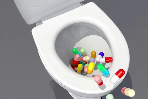 Tabletten fallen in eine Toilette