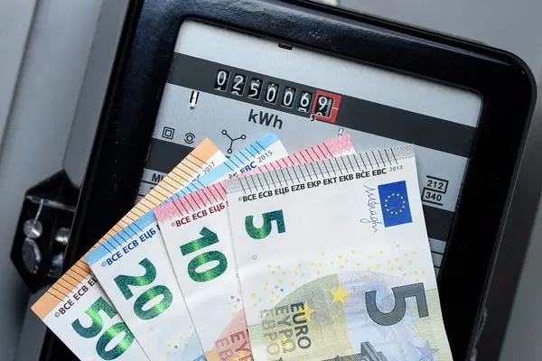 Geldscheine sind vor einem Stromzähler zu sehen