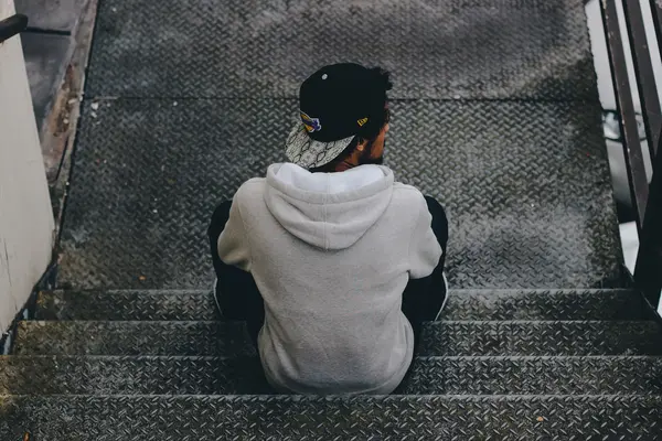 junger Mann sitzt auf einer Treppe