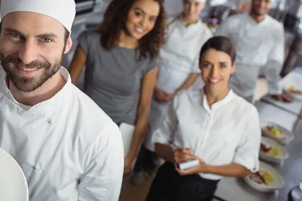 Ein Küchenteam lächelt in die Kamera