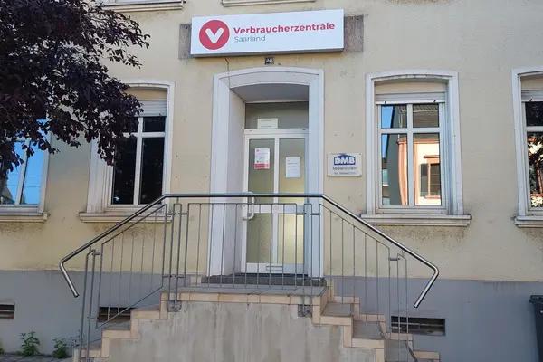 Frontansicht eines gelben Hauses mit beidseitigem Treppenaufgang