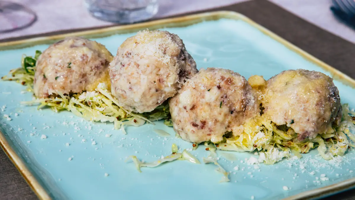 Knödel liegen auf Salat auf einem Teller
