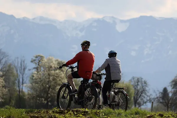 Ein älteres Paar auf E-Bikes in den Bergen