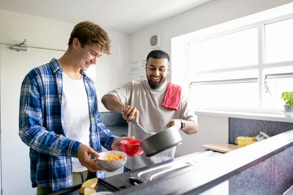 Zwei Männer kochen gemeinsam in einer Küche