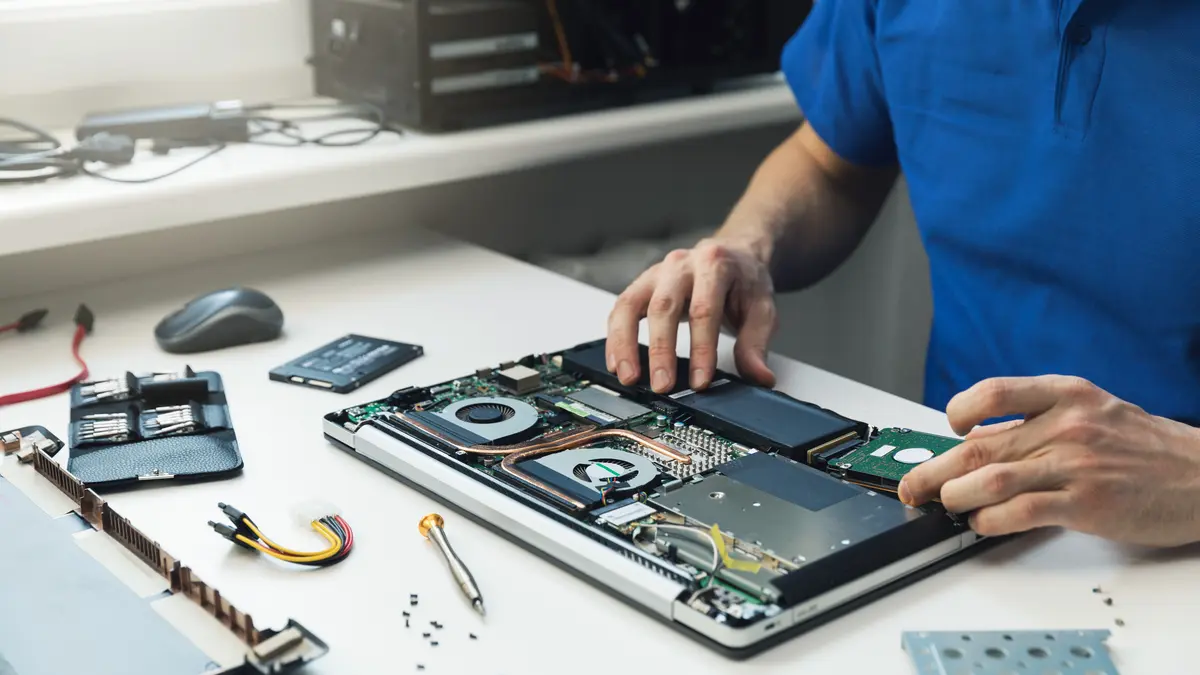 Ein Mann versucht, einen kaputten Laptop zu reparieren.