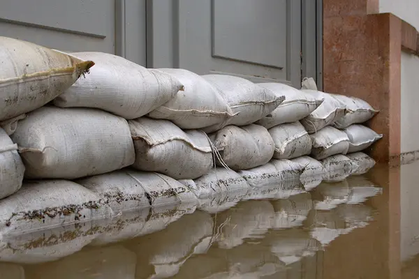 Sandsäcke vor einem Gebäude im Hochwasser