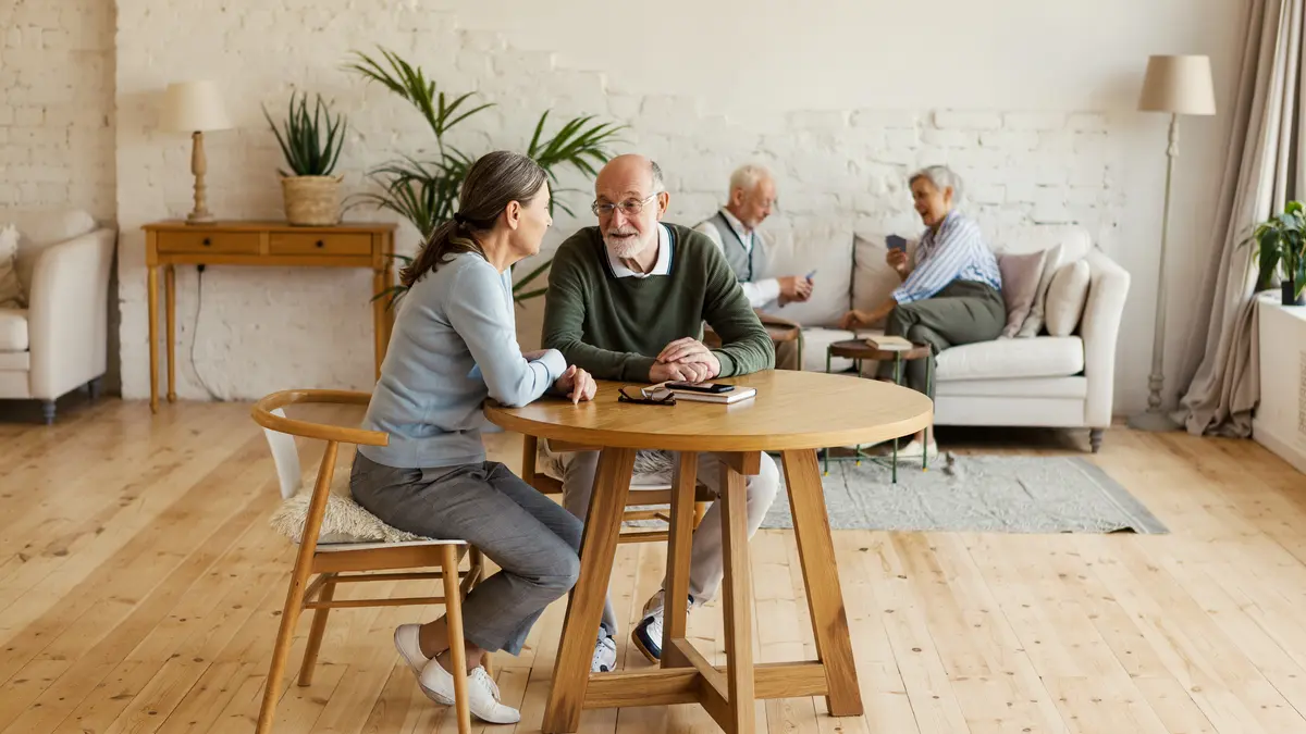 Vier Senioren sitzen in einem Gemeinschaftsraum