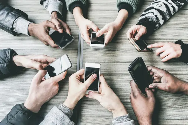 Viele Hände im Kreis mit Smartphones