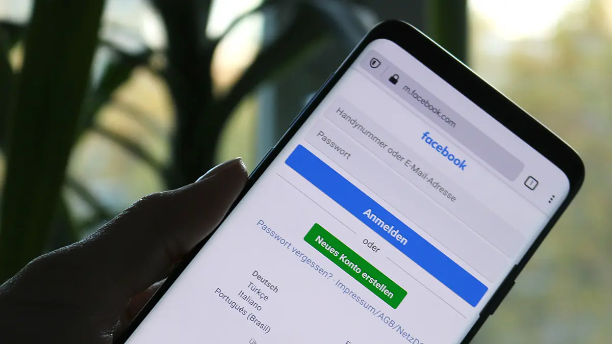 Hand hält Smartphone mit Facebook-Anmeldeseite