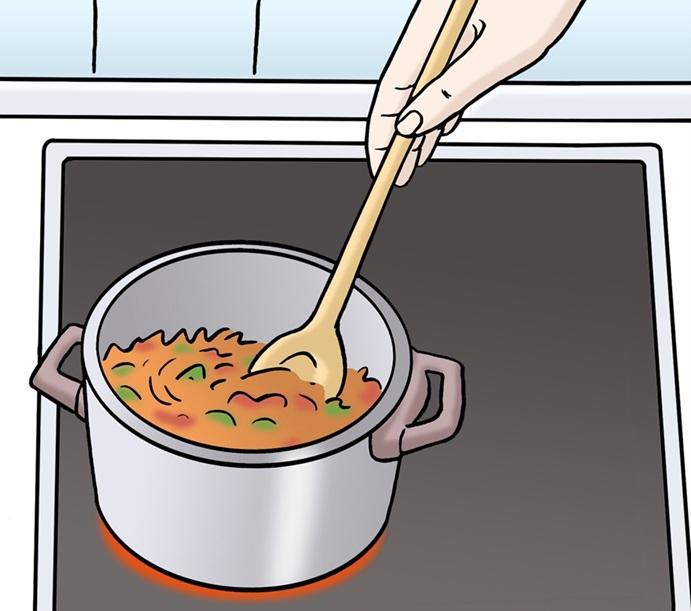 Topf mit Suppe auf dem Herd mit Hand und Holzlöffel